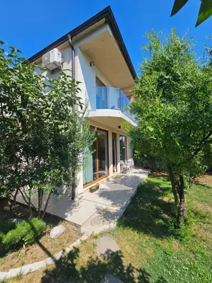 a white house with trees in front of it at Apartments Aerodrom in Podgorica