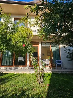 a house with a porch with a chair and a table at Apartments Aerodrom in Podgorica