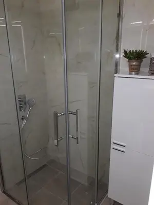 a shower stall with a glass shower door at Seahaven in Petrovac na Moru