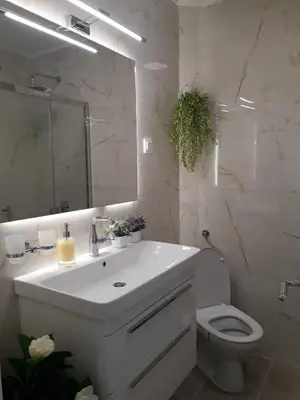 a bathroom with a sink and a toilet and a mirror at Seahaven in Petrovac na Moru