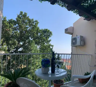a table with a bottle of wine on a balcony at Seahaven in Petrovac na Moru