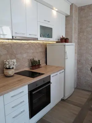 a kitchen with white cabinets and a wooden counter top at Seahaven in Petrovac na Moru