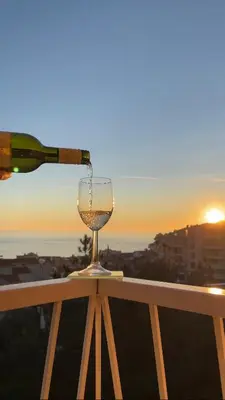 a wine glass sitting on a railing with a wine bottle at Seahaven in Petrovac na Moru
