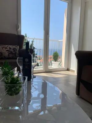 a living room with a table with a bottle of wine at Seahaven in Petrovac na Moru