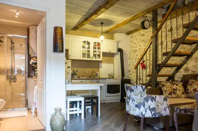 a kitchen and living room with a table and a staircase at Rijeka Crnojevića, Lidija Apartment in Rijeka Crnojevića