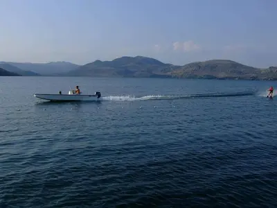 a man on a boat in the water at Rijeka Crnojevića, Lidija Apartment in Rijeka Crnojevića