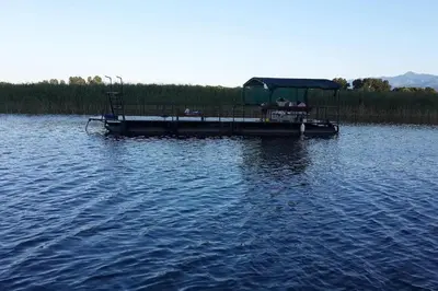 a small dock on a lake with people on it at Rijeka Crnojevića, Lidija Apartment in Rijeka Crnojevića