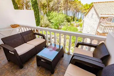 a balcony with a couch and chairs and a table at Apartments Adriatic in Sveti Stefan