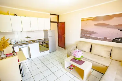 a living room with a couch and a kitchen at Apartments Adriatic in Sveti Stefan