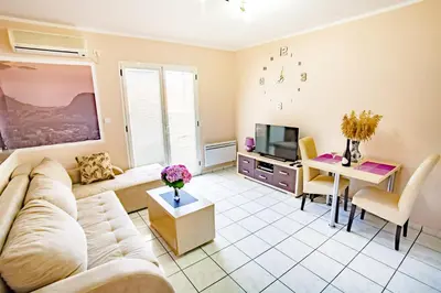 a living room with a couch and a tv at Apartments Adriatic in Sveti Stefan