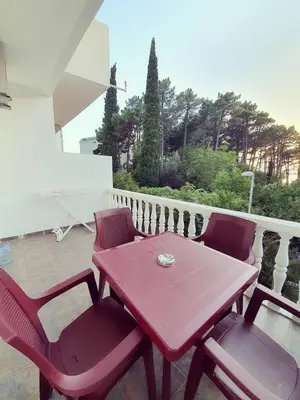 a red table and chairs sitting on a balcony at Apartments Adriatic in Sveti Stefan