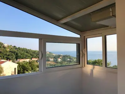 a room with windows with a view of the ocean at Kuća Radović in Budva