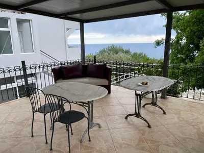 a patio with a couch and a table and chairs at Kuća Radović in Budva