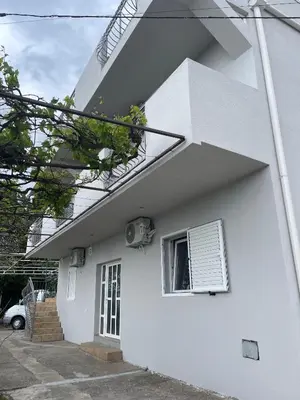 a white house with a window on the side of it at Kuća Radović in Budva