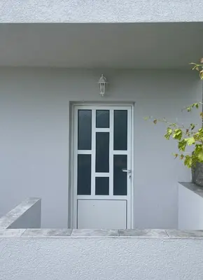 a white door on a white house at Kuća Radović in Budva