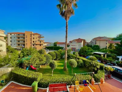 a park with a palm tree and a playground at Vila L Budva in Budva