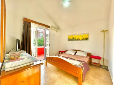 a bedroom with a bed and a television in it at Vila L Budva in Budva