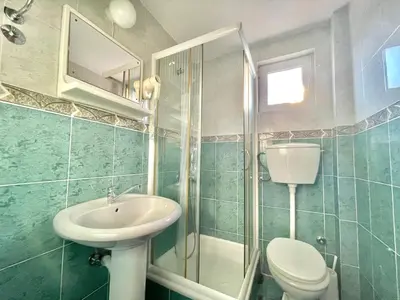 a bathroom with a sink and a toilet and a shower at Vila L Budva in Budva
