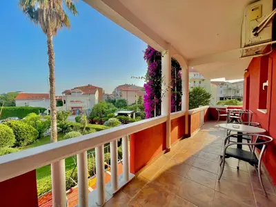 a balcony with a table and chairs and a palm tree at Vila L Budva in Budva