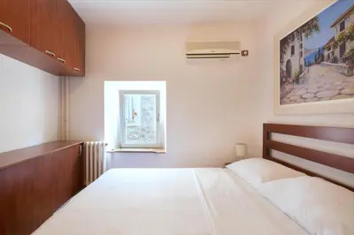 a bedroom with a large bed and a window at Apartment Kovacevic Old Town in Budva