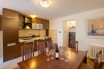 a kitchen with a wooden table with wine glasses on it at Apartment Kovacevic Old Town in Budva