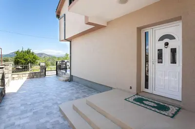 a house with a white door and a balcony at Luxury House Petrovic - Vranjina Skadar Lake in Podgorica