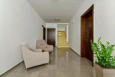 a living room with two chairs and a staircase at Apartmani Djurovic in Ulcinj