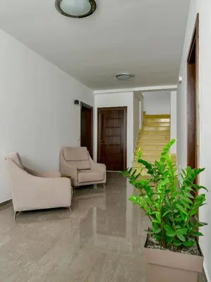 a living room with two chairs and a staircase at Apartmani Djurovic in Ulcinj