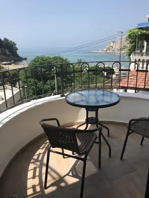 a table and chairs on a balcony with a view of the ocean at Apartmani Djurovic in Ulcinj