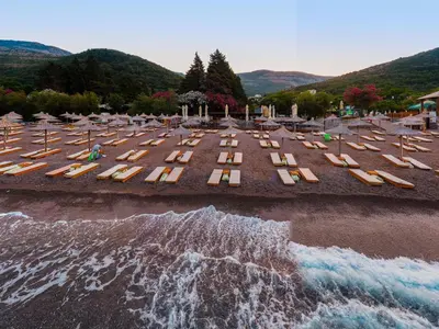 an aerial view of a beach with chairs and the ocean at Hotel Plaza Lucice in Petrovac na Moru