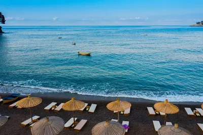 a group of chairs and umbrellas on the beach at Hotel Plaza Lucice in Petrovac na Moru