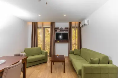 a living room with two green couches and a table at Hotel Plaza Lucice in Petrovac na Moru
