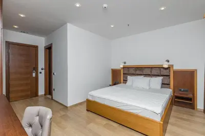 a bedroom with a bed and a chair at Hotel Plaza Lucice in Petrovac na Moru