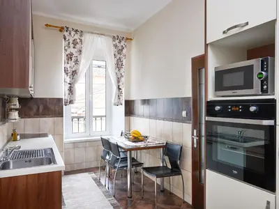 a kitchen with a table with chairs and a microwave at Apartment Palata Bizanti in Kotor