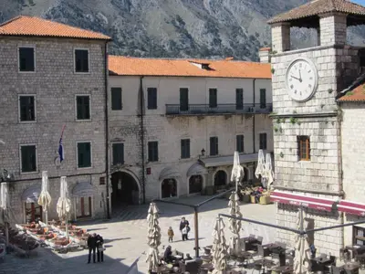 a large building with a clock tower in a courtyard at Apartment Palata Bizanti in Kotor