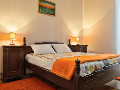a bedroom with a bed with an orange blanket at Apartment Palata Bizanti in Kotor