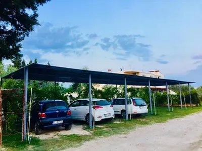 a group of cars parked under a blue canopy at Flamingo Cottage in Ulcinj