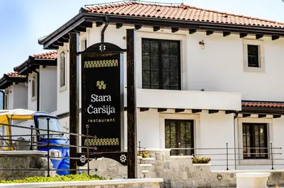 a white house with a sign in front of it at Stara Čaršija Hotel & SPA in Bar