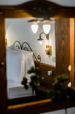 a reflection of a bedroom with a bed in a mirror at Stara Čaršija Hotel & SPA in Bar