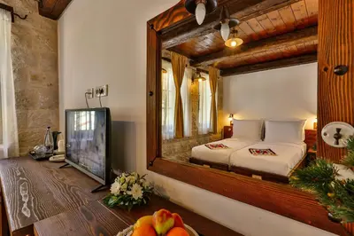 a bedroom with a mirror and a bed and a tv at Stara Čaršija Hotel & SPA in Bar