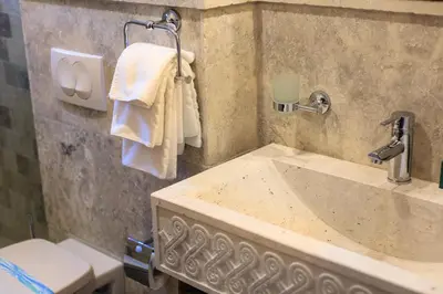 a bathroom with a sink and a toilet and towels at Stara Čaršija Hotel & SPA in Bar
