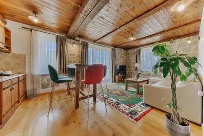 a kitchen and living room with a table and chairs at Stara Čaršija Hotel & SPA in Bar