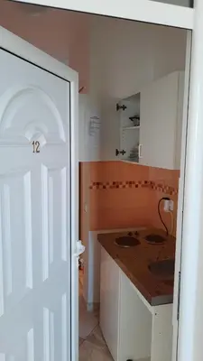 a small kitchen with two sinks and a counter at Apartmani Vila Milaris in Ulcinj