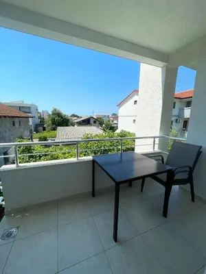 a black table and a chair on a balcony at Apartmani Vila Milaris in Ulcinj