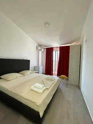 a bedroom with a large bed with two towels on it at Apartmani Vila Milaris in Ulcinj