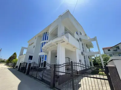 a white building with a fence in front of it at Apartmani Vila Milaris in Ulcinj