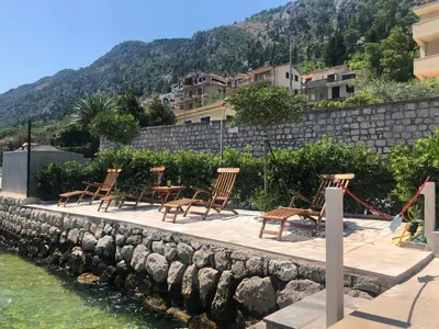 a group of chairs sitting on a dock next to the water at Luxury Waterfront Villa with Private Pool and Private Beach for 12 People in Kotor
