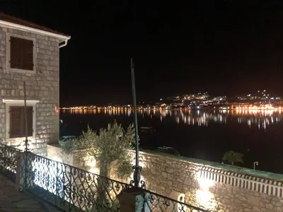 a view of the water at night from a balcony at Luxury Waterfront Villa with Private Pool and Private Beach for 12 People in Kotor