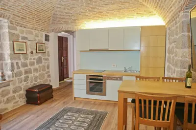 a kitchen with a table and a dining room at Luxury Waterfront Villa with Private Pool and Private Beach for 12 People in Kotor