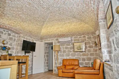 a living room with a stone wall at Luxury Waterfront Villa with Private Pool and Private Beach for 12 People in Kotor